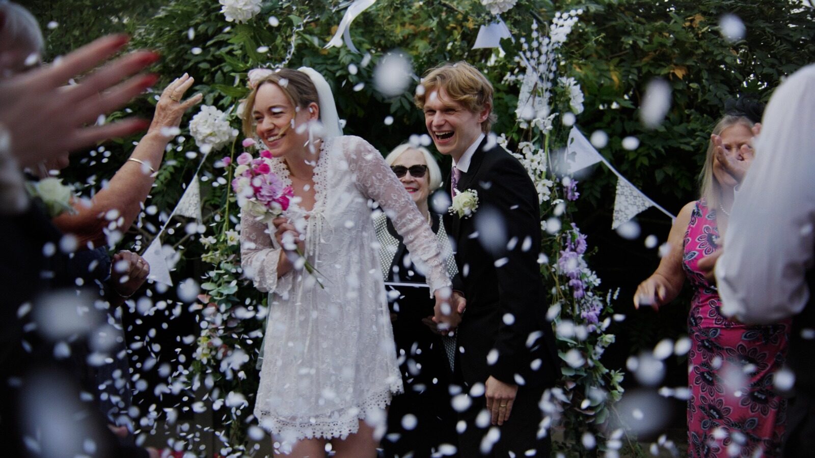 Newlyweds walking through a shower of confetti